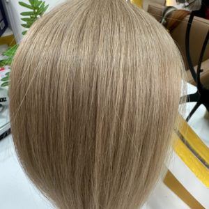 A close-up of smooth, straight, and silky Color 18M blonde hair extensions displayed on a mannequin head, reflecting a natural shine in a salon setting.