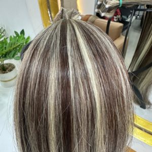 High-quality Color 4/22 hair extensions featuring a blend of warm brown and blonde highlights. The extensions are bundled and displayed in a salon setting.
