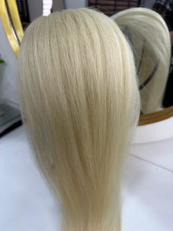 Color 60 blonde hair extensions – A close-up image of silky, straight, platinum blonde (Color 60) hair extensions displayed on a stand with a mirror in the background.