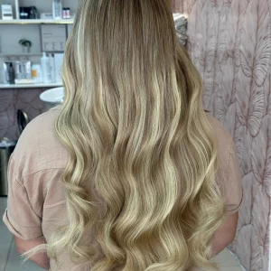 Color 8/22 hair extensions in 22-inch length, featuring a blend of light and dark blonde tones. Displayed on a mannequin head in a salon setting.