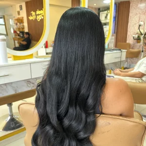 Smooth, silky black hair extensions displayed on a mannequin head, reflecting a natural shine with a sleek and straight texture.