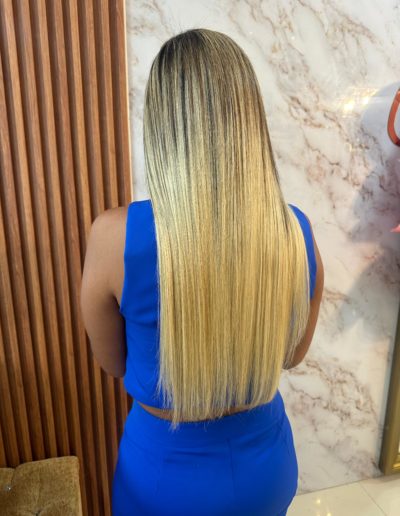 22-inch balayage hair extensions with a natural blend of dark brown roots transitioning to blonde. High-quality, smooth, and silky texture with adhesive application.